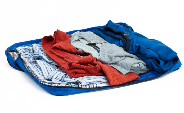 An open Large Tri-Star Packing Cube in Island (blue) 120 Aether filled with shirts.